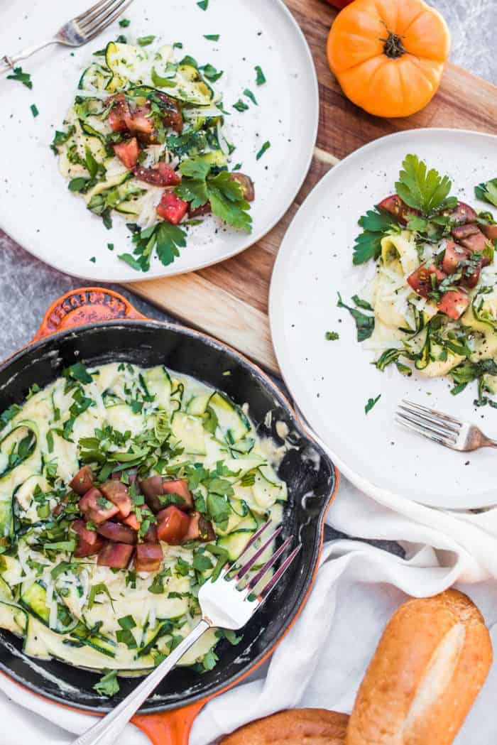 2 plates of zucchini ribbonos with alredo sauce and fresh garden tomatoes