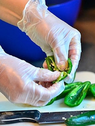 Wearing Kitchen Gloves While Chopping Jalapeño Peppers