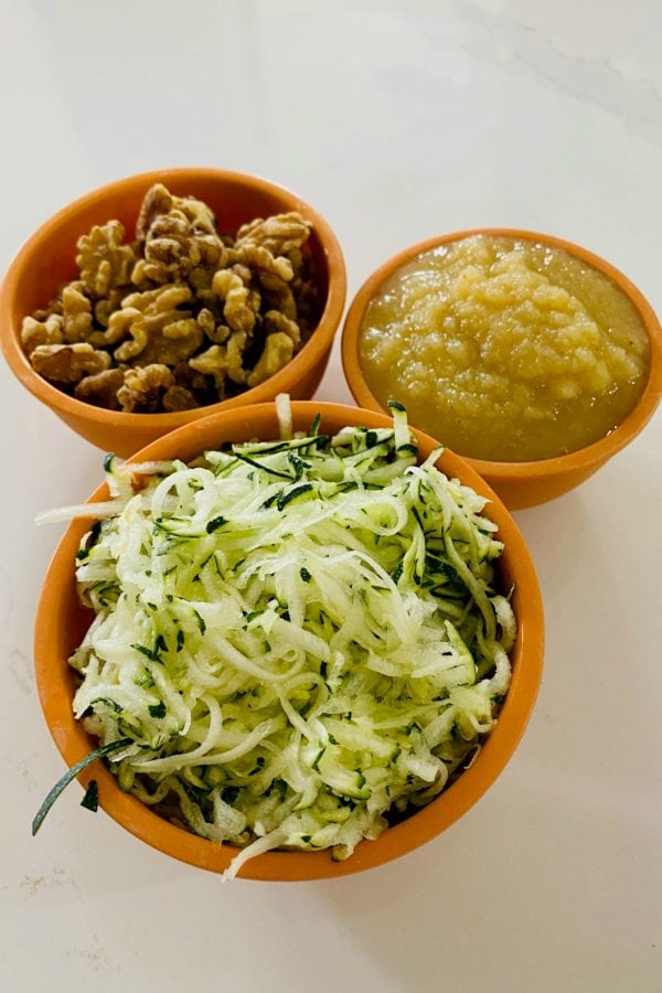 bowls of walnuts, applesauce, and shredded zucchini