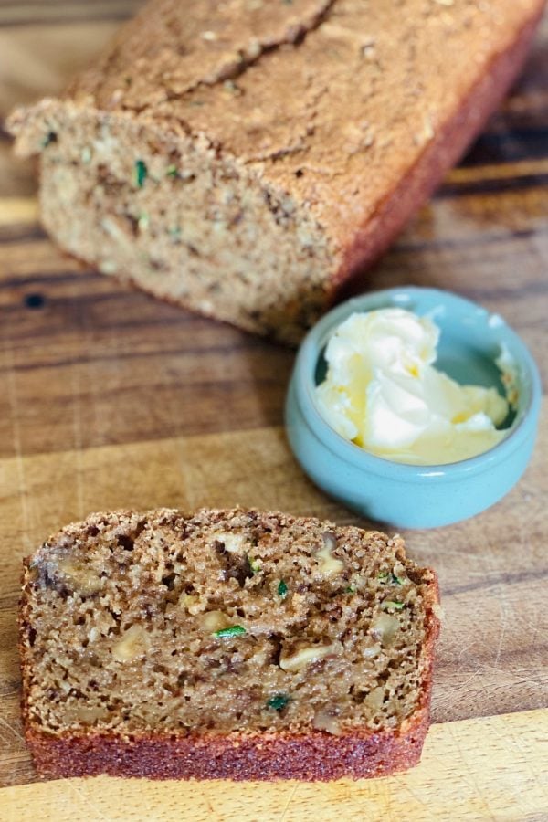 a slice of Organic Zucchini Applesauce Bread with butter in a small dish