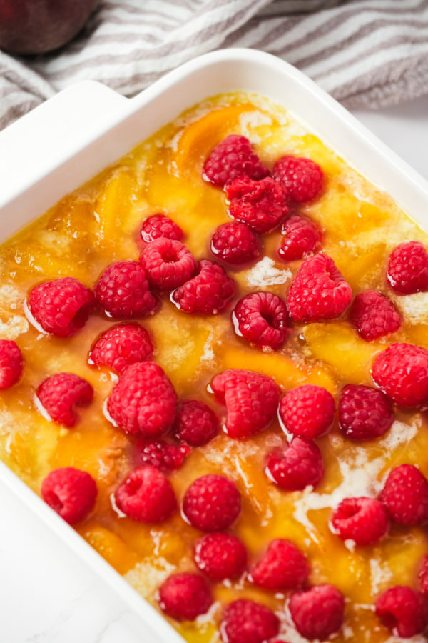 adding fresh raspberries to a cobbler