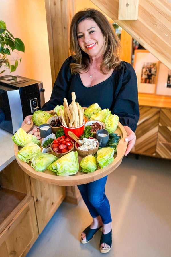 woman holding a wedge salad board