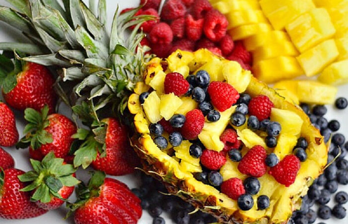 a pineapple scooped out into a bowl to hold fruit