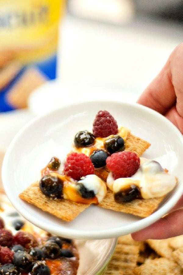 salted caramel yogurt dip on salty crackers with fresh berries