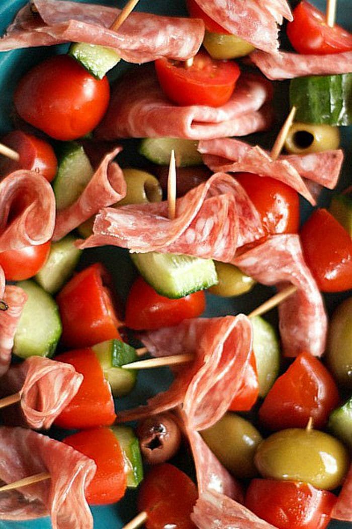 salami folded, a chunk of tomato and cucumber and an olive, skewered on a toothpick