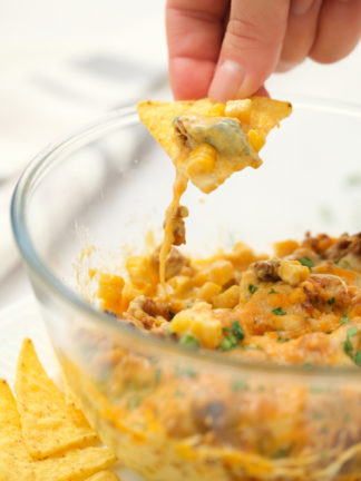 taking a bite of Corn Chorizo Dip