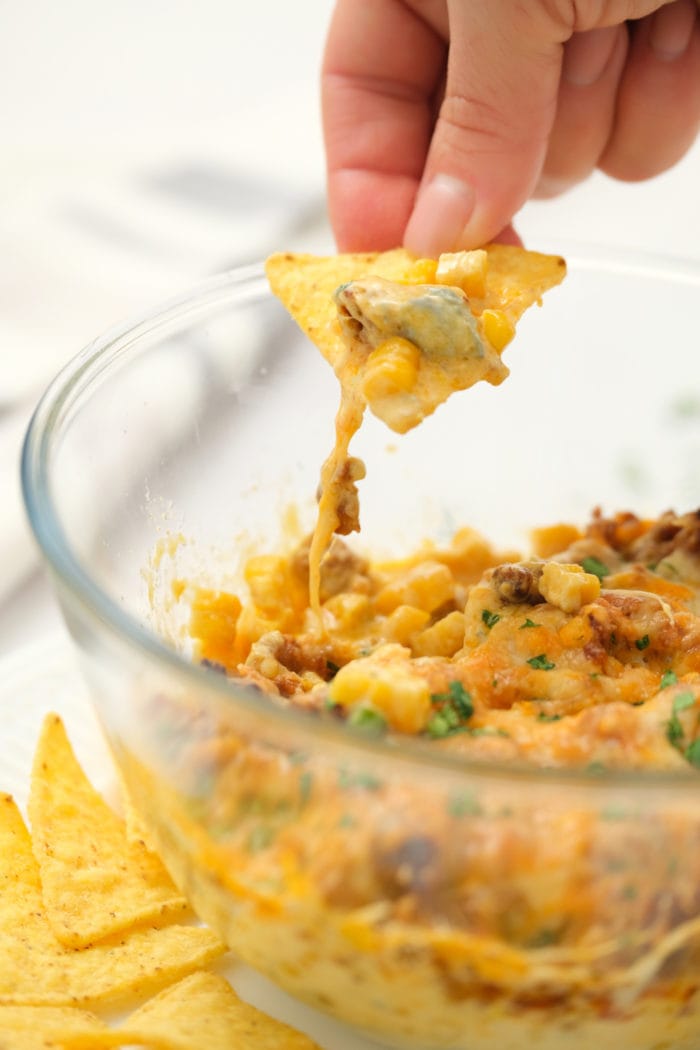 taking a bite of Corn Chorizo Dip