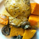 plate of cooked chicken thighs with mushrooms and sweet potatoes