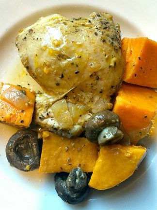 plate of cooked chicken thighs with mushrooms and sweet potatoes