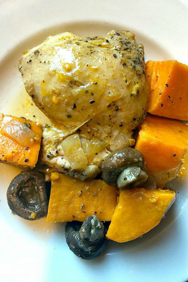 plate of cooked chicken thighs with mushrooms and sweet potatoes