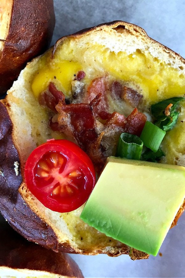 baked bacon and egg pretzel roll with avocado