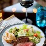 beautiful plate of tri tip with salad, and a glass of wine