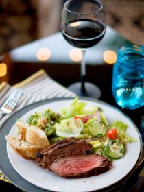 beautiful plate of tri tip with salad, and a glass of wine