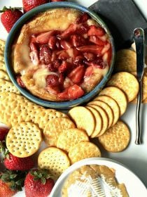 roasted strawberries on top of a hot brie with crackers