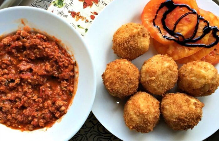 serving rice balls with tomato slices and balsamic glaze