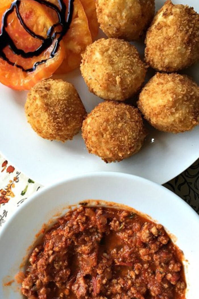 serving Arancini al Forno with meat sauce