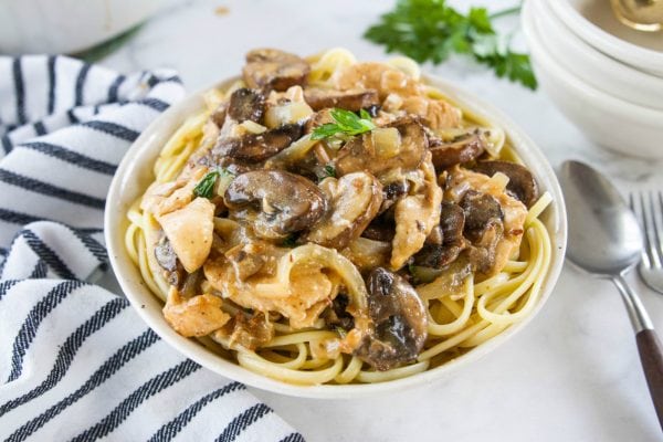 a bowl of chicken marsala on pasta