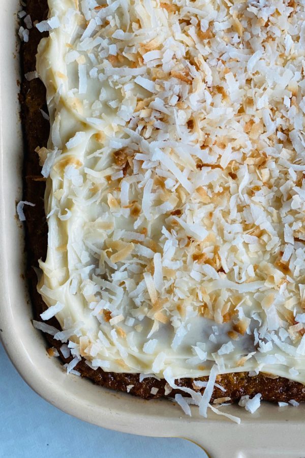 close up cream cheese frosting with coconut on a pineapple cake