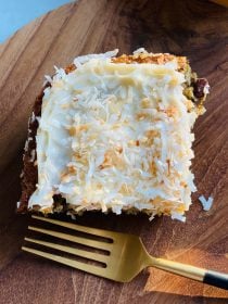 piece of pineapple cake with cream cheese frosting and toasted coconut