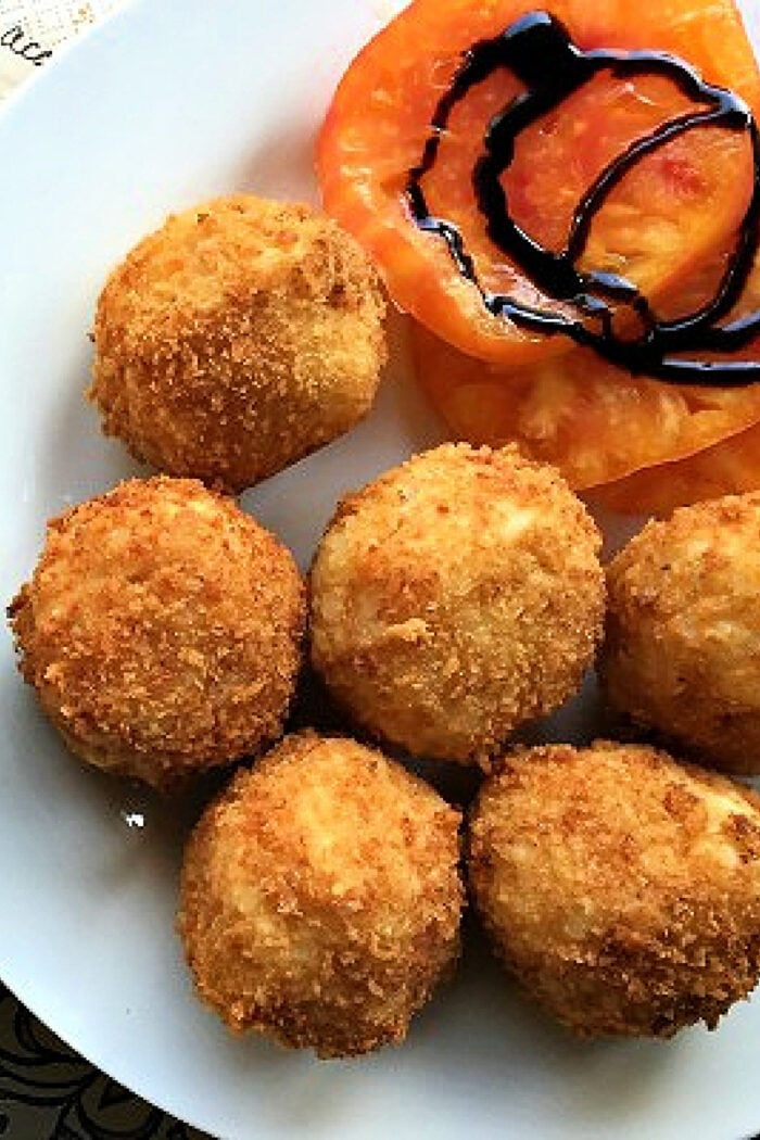 serving Arancini al Forno with tomato slices