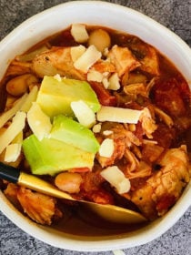 white bowl of bowl of white bean chicken chili with cheese