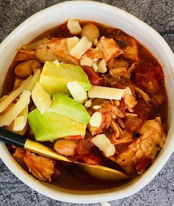 white bowl of bowl of white bean chicken chili with cheese