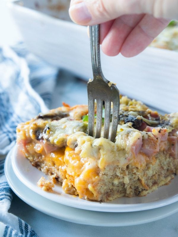 a fork in a square piece of baked ham breakfast bake