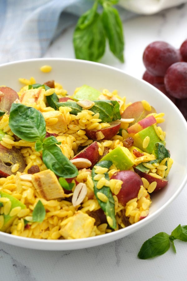 curried orzo salad in a white serving bowl