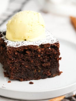 cake with powdered sugar and a scoop of vanilla ice cream