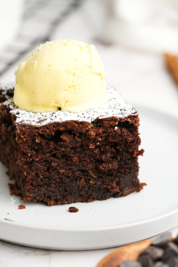 cake with powdered sugar and a scoop of vanilla ice cream