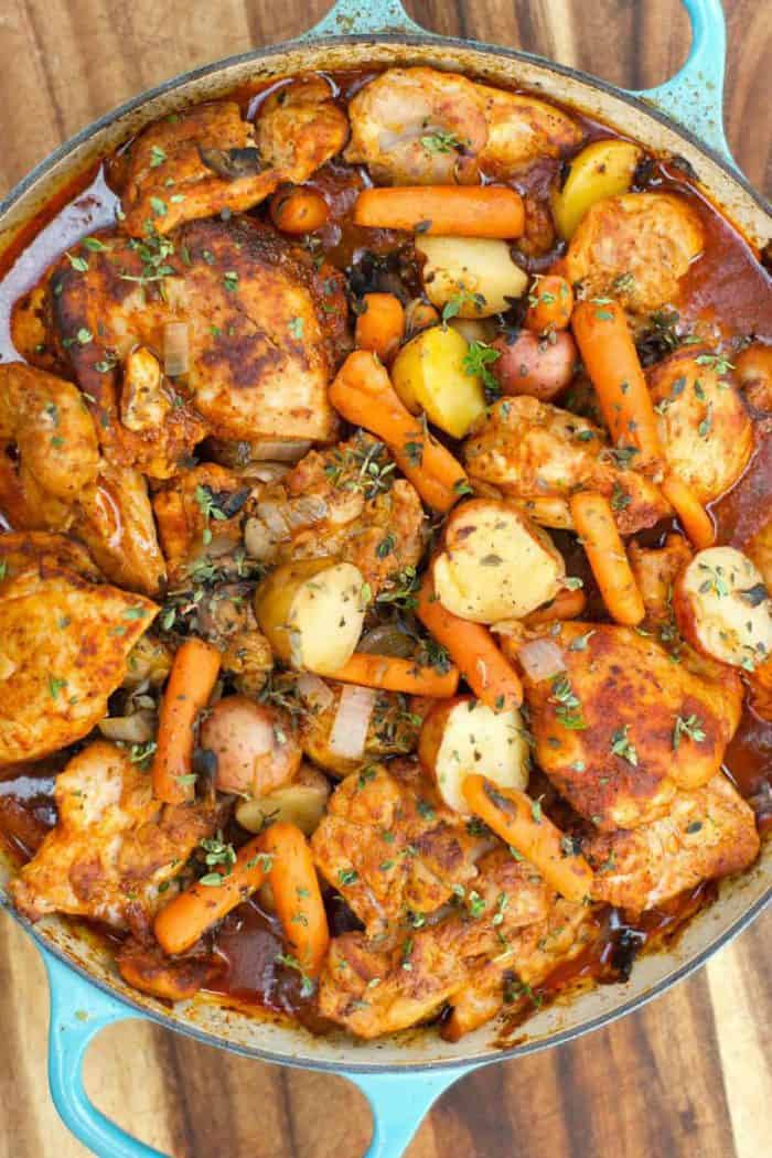 beautiful photo of paprika chicken thighs with potatoes and carrtots, cooked in a dutch oven