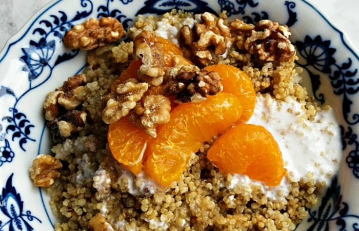 a bowl of quinoa, mandarin oranges, walnuts, and yogurt