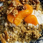 a breakfast bowl of quinoa, walnuts, mandarin oranges, and yogurt