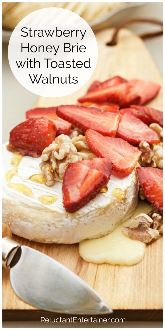 round of melted brie with fresh strawberries, toasted walnuts and drizzled honey