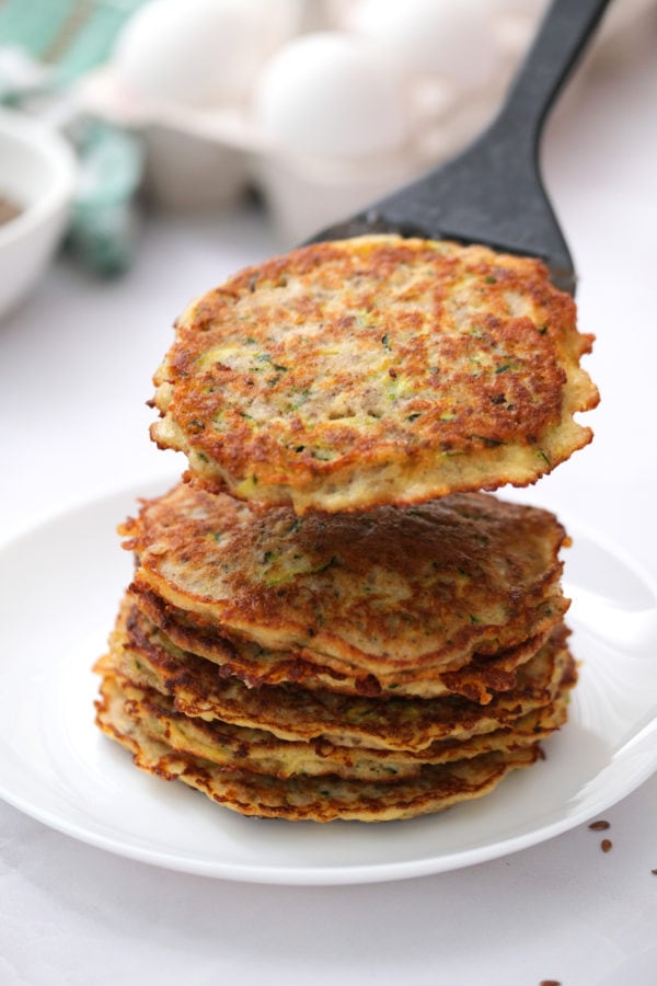 stacking zucchini pancakes on a plate