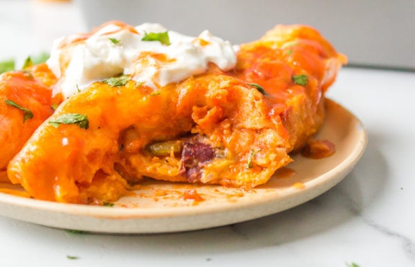 plate of enchilada with sour cream