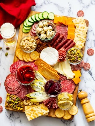 wood board of meat and cheese charcuterie with olives
