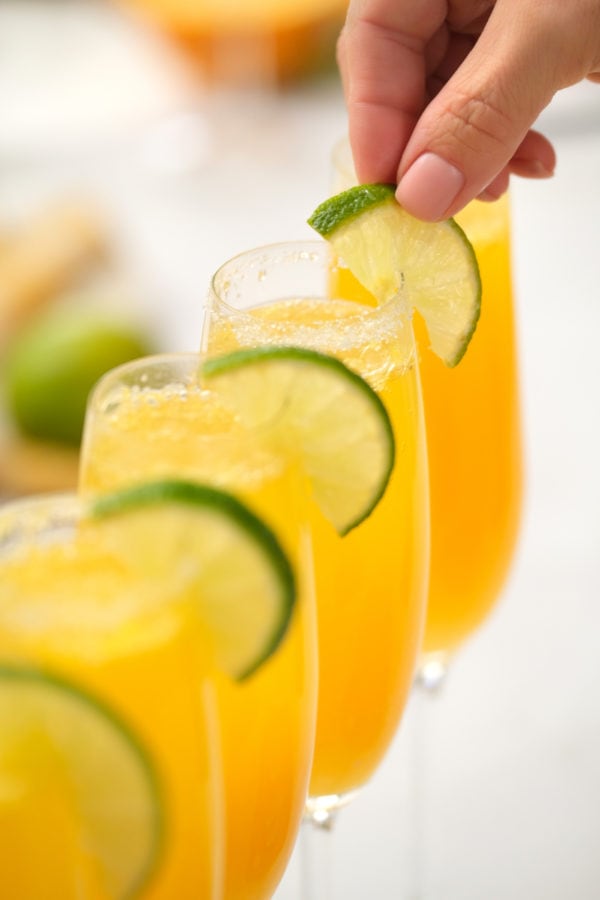 adding fresh lime to bellini glasses