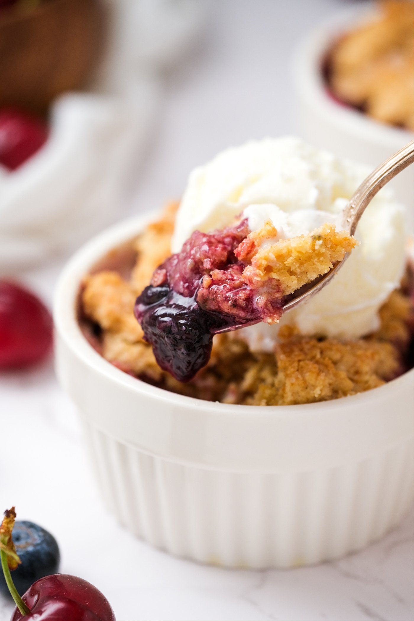 a bite of Cherry Blueberry Cobbler with ice cream