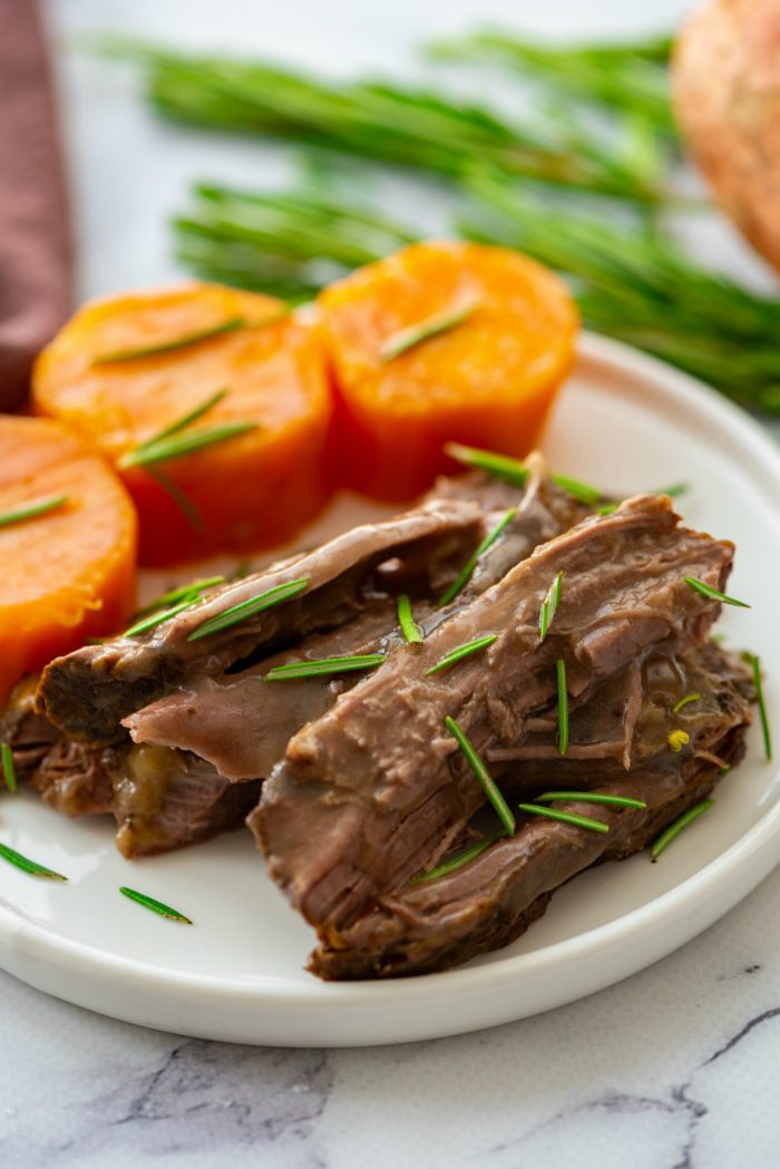 plate with slow cooked roast and sliced sweet potatoes