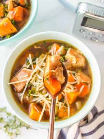 a bite of soup with chicken and sweet potatoes