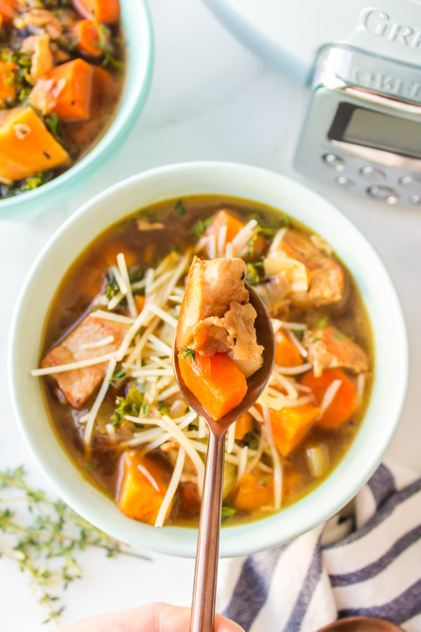 a bite of soup with chicken and sweet potatoes