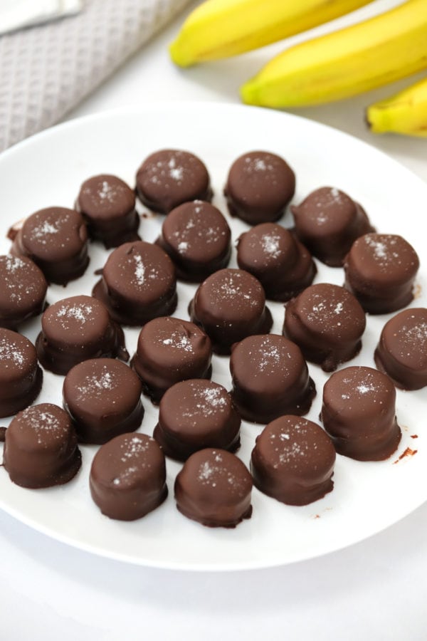 a plate of frozen banana bites covered in chocolate