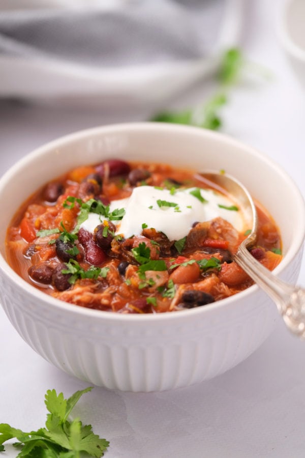 Instant Pot Mango Chicken Chili with sour cream and a spoon