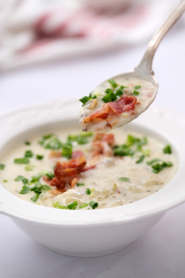 a spoonful of best clam chowder with bacon and chives