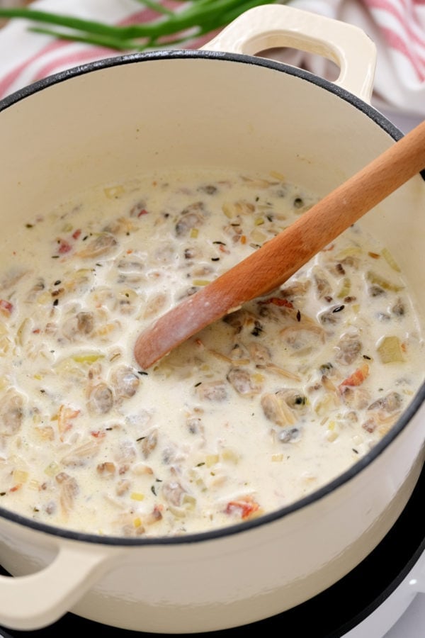 stirring a pot of best clam chowder