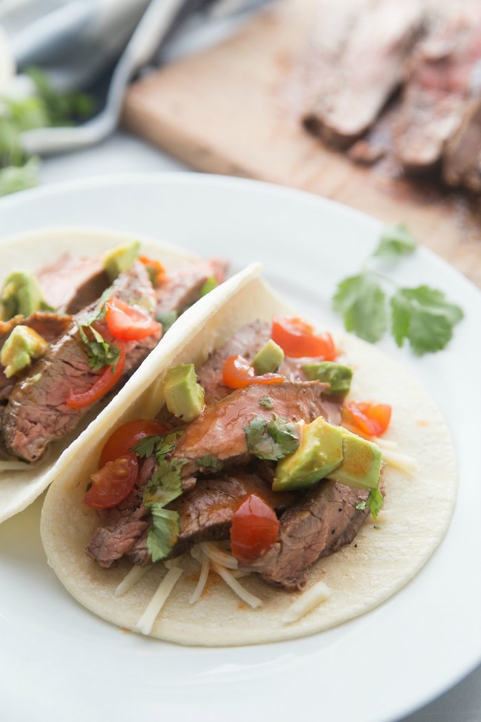 flank steak tacos with avocado, tomatoes, and cilantro