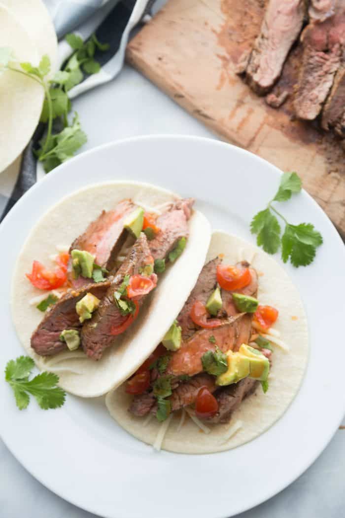 a plate of 2 delicious flank steak tacos