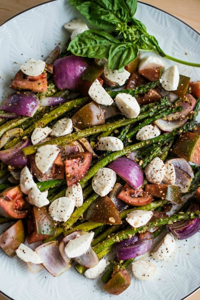Pesto Asparagus Caprese Salad Recipe with mozzarella cheese, red onions, and tomatoes
