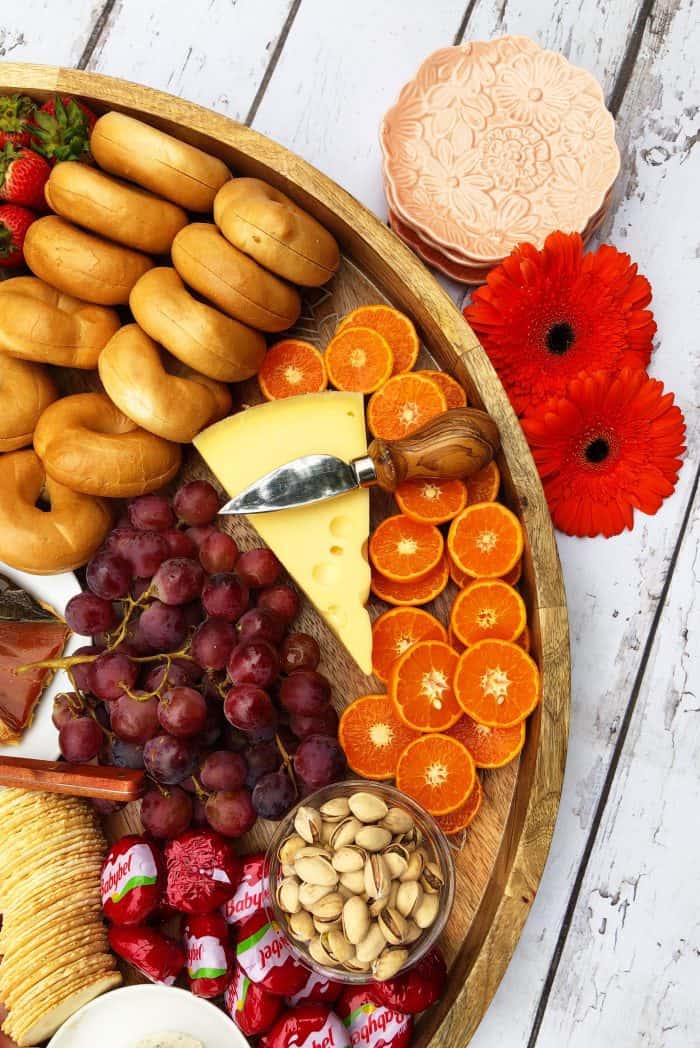 Big round beautiful Sunday Brunch Cheese Board with salmon, boiled eggs, mini bagels